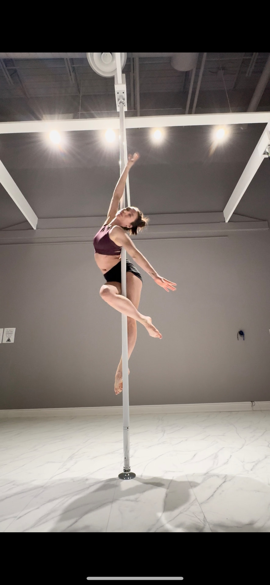 Ira on the pole in a bright studio